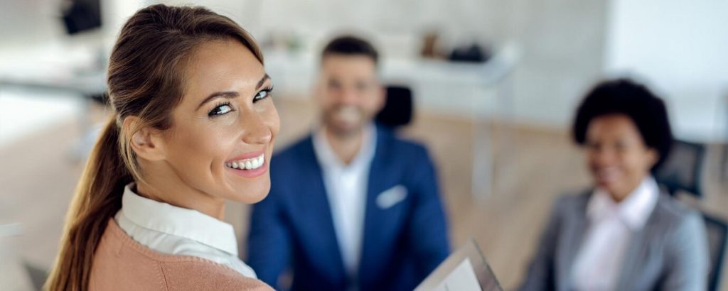 Femme qui sourie à un entretien avec deux personnes