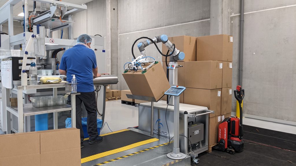 Équipement industriel, bras robotisé portant un carton